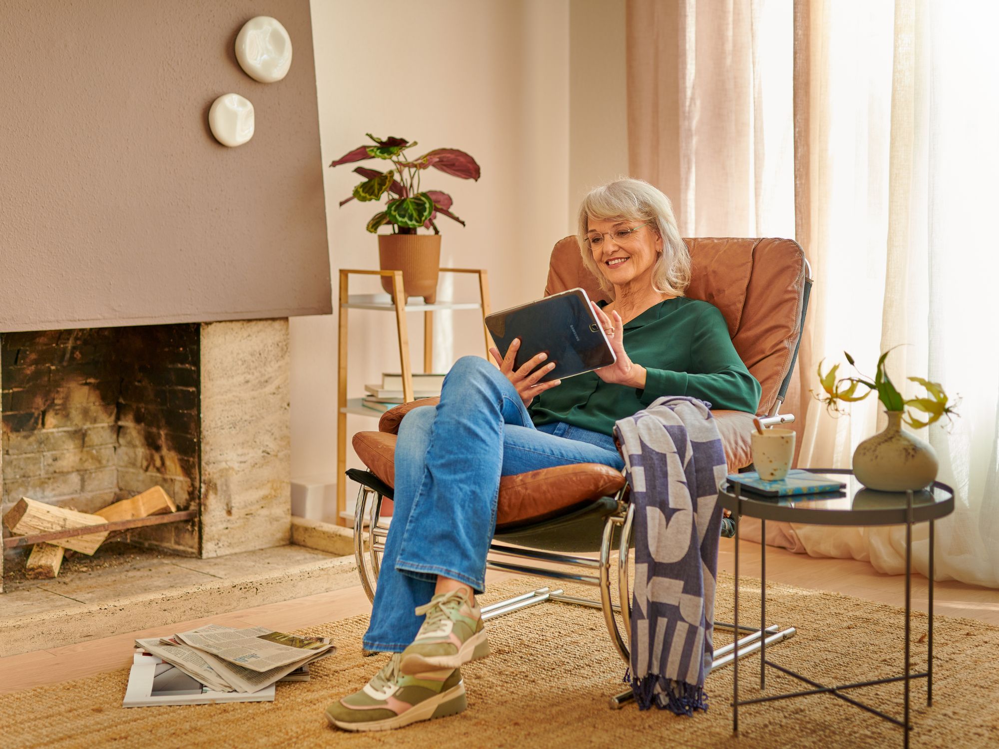 Vrouw van middelbare leeftijd speelt thuis een spelletje op haar tablet.