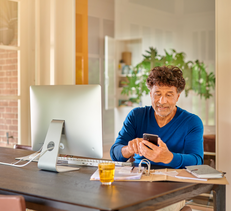 Man voert een code in op zijn telefoon om in te loggen met DigiD op zijn computer.