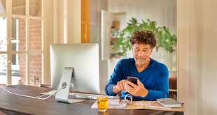 Man voert een code in op zijn telefoon om in te loggen met DigiD op zijn computer.
