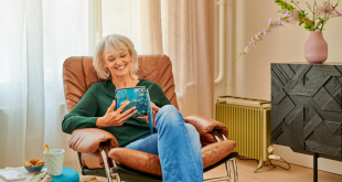 Een vrouw zit in een comfortabele stoel en leest een boek op een e-reader.